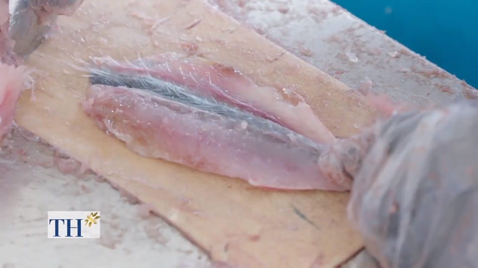 Cầm chiếc thìa bạn xẻ con cá làm hai theo đường xương chính giữa của nó và nạo hết để lấy thịt nó ra